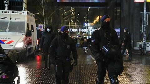 Niederländische Polizisten patrouillieren vor einem Ministeriumsgebäude.