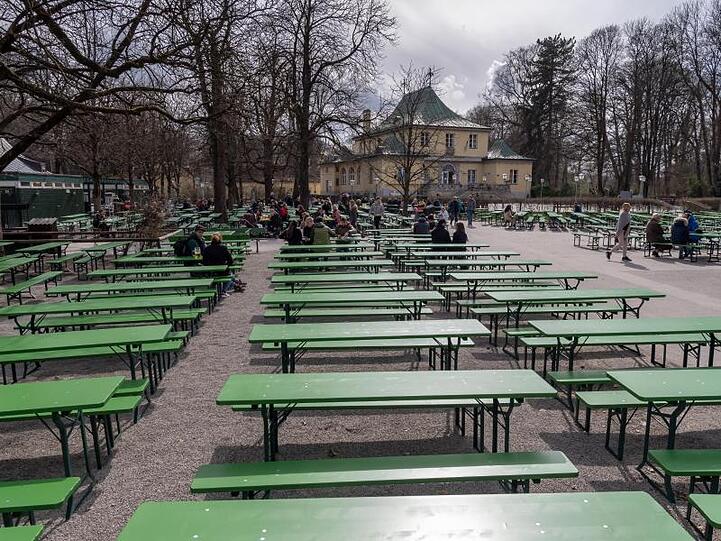 Viele freie Bänke stehen in einem Biergarten. Foto: Peter Kneffel/dpa