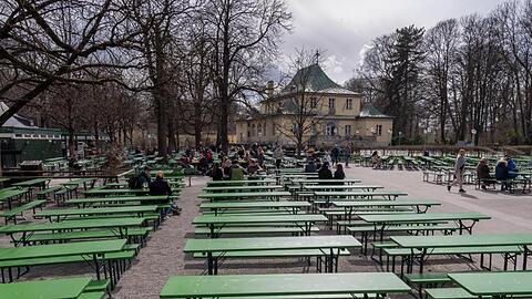 Viele freie Bänke stehen in einem Biergarten. Foto: Peter Kneffel/dpa