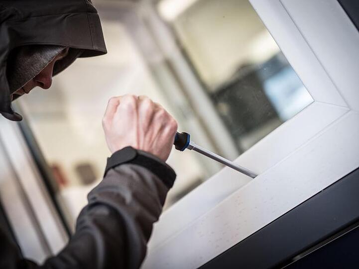 Ein Mann versucht ein Fenster mit einem Schraubenzieher zu öffnen. Foto: Frank Rumpenhorst/Archiv