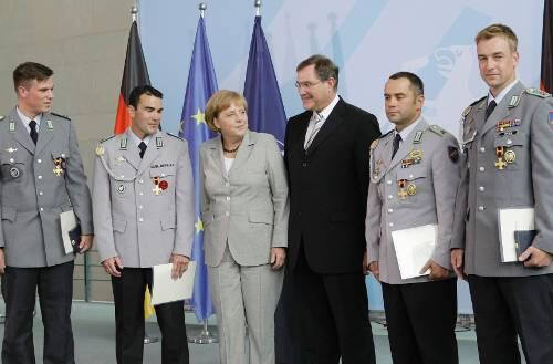 Kanzlerin Merkel und Verteidigungsminister Jung mit den vier geehrten Feldwebeln.