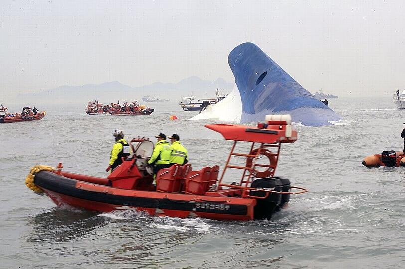 Boote suchen nach Überlebenden - die Fähre versinkt in den Fluten.