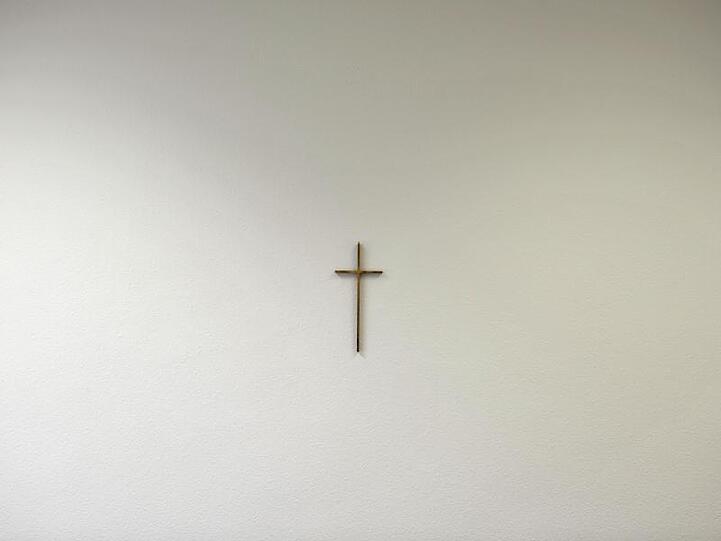 Ein Kreuz hängt an der Wand. Foto: picture alliance / dpa/Archivbild