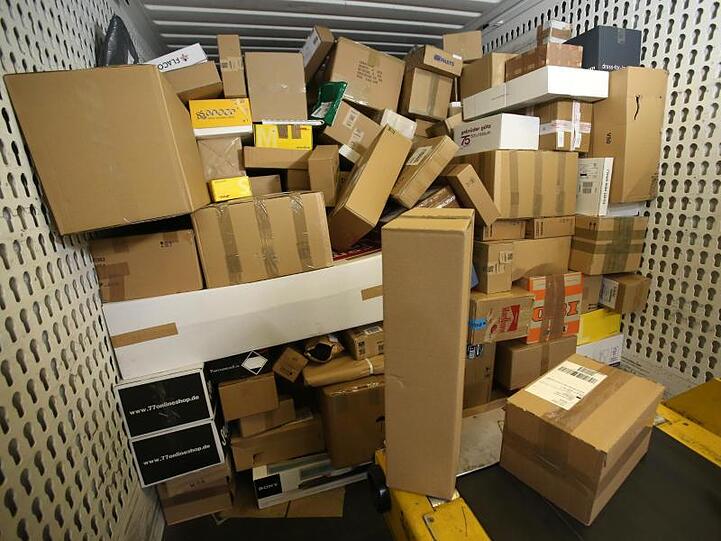 In einer Paket-Zustellbasis steht eine LKW-Ladung Pakete. Foto: Bernd Wüstneck/dpa-Zentralbild/dpa