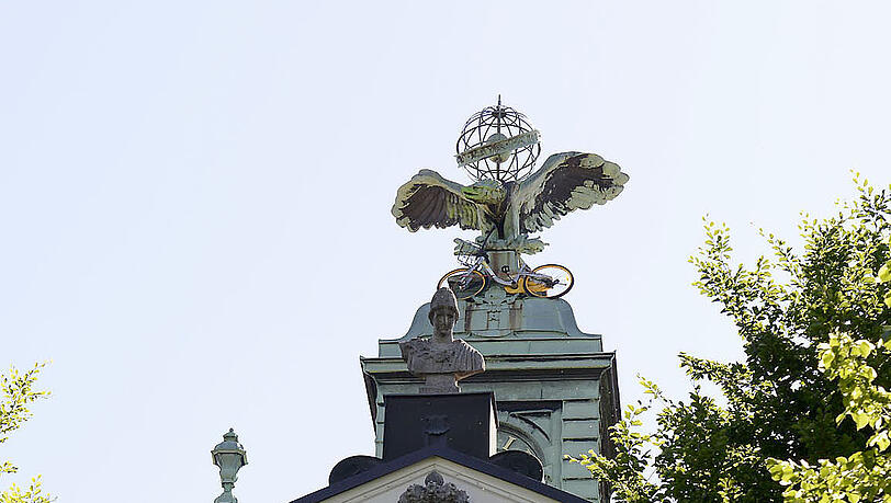 Unbekannte "parken" zwei Fahrräder auf dem Uhrenturm einer Münchner Schule. Unbekannte "parken" zwei Fahrräder auf dem Uhrenturm einer Münchner Schule.