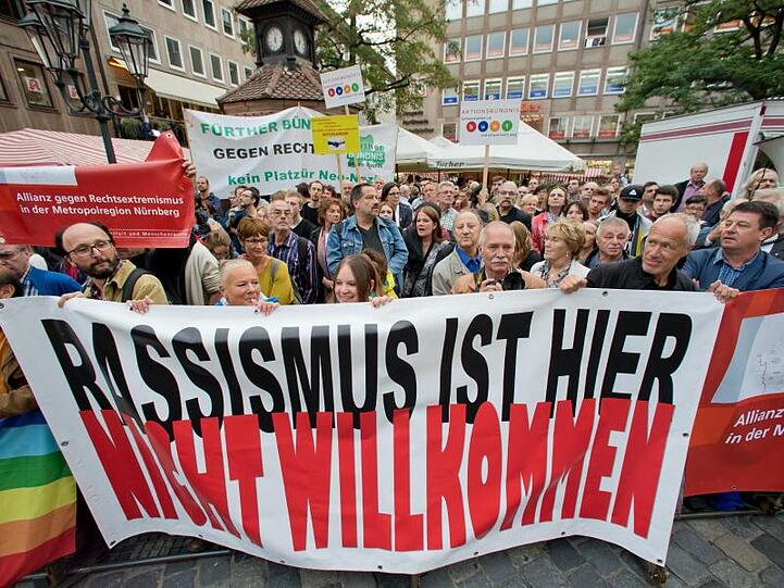 "Rassismus ist hier nicht willkommen" ist auf einem Plakat zu sehen. Foto: Daniel Karmann/dpa