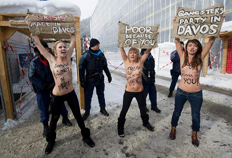Nacktprotest in Davos: Ukrainerinnen demonstrieren barbusig am Zaun vor dem Weltwirtschaftsforum. Die Polizei greift ein - die Bilder.