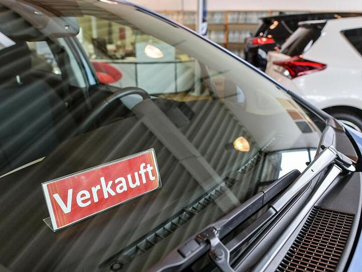Ein Schild mit der Aufschrift "Verkauft" steht in einem Fahrzeug bei einem Autohändler.