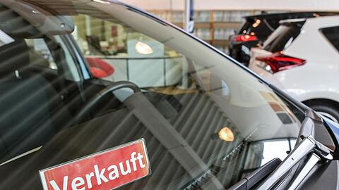 Ein Schild mit der Aufschrift "Verkauft" steht in einem Fahrzeug bei einem Autohändler.