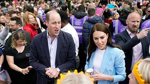 William (Mitte l), Prinz von Wales, und Kate (Mitte r), Prinzessin von Wales, mischen sich am Sonntag in der Nähe von Schloss Windsor unters Volk.