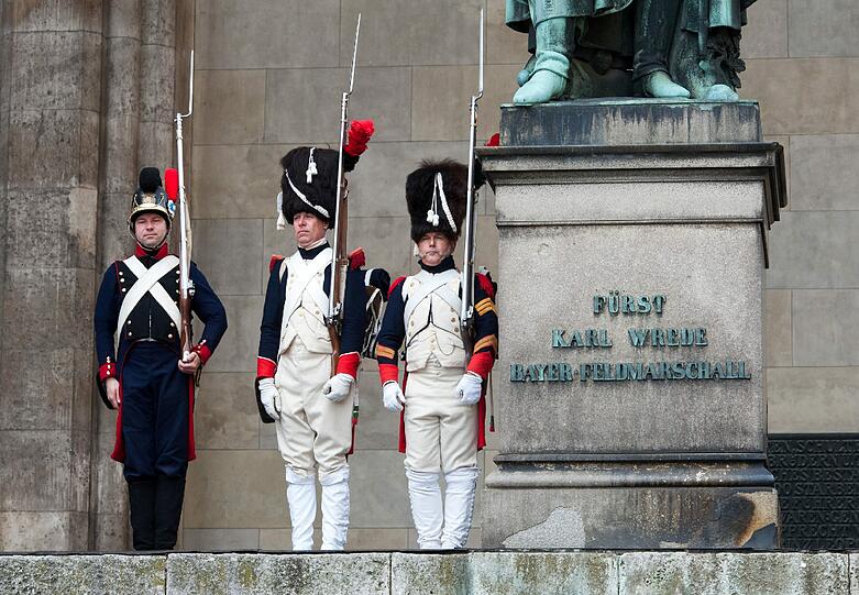 Die vielen Passanten und Touristen schauten verwundert auf dieses Szene: Drei Männer in historischen Soldatenuniformen standen am Freitag neben dem Denkmal des bayerischen Feldmarschalls Fürst Karl Wrede in der Feldherrnhalle am Odeonsplatz.