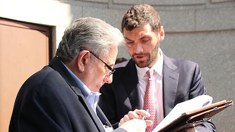 Nach der Auktion bekommt Jeff Gural (l) von Auktionator Matthew Mannion einen Stift gereicht.