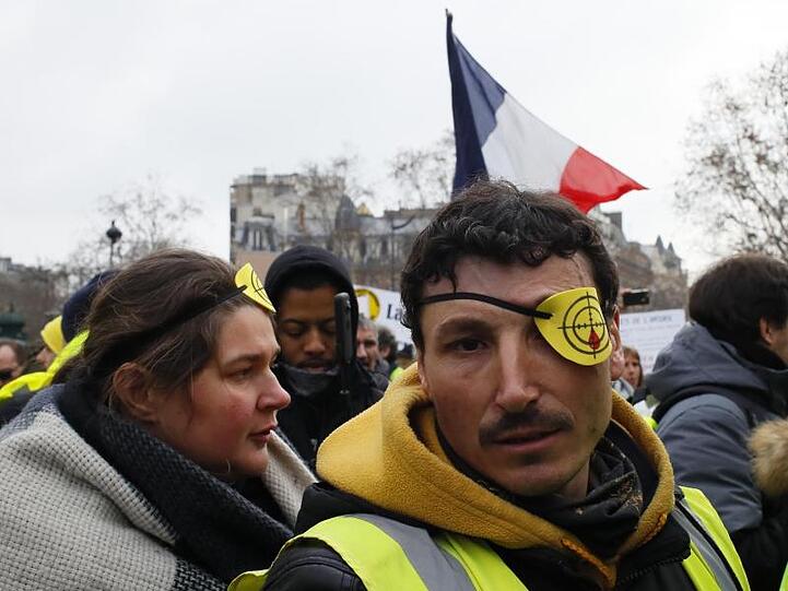 Demonstranten in Paris tragen Augenklappen mit Fadenkreuz, um an Verletzte zu erinnern, die durch Gummigeschosse der Polizei ihr Auge verloren hatten.