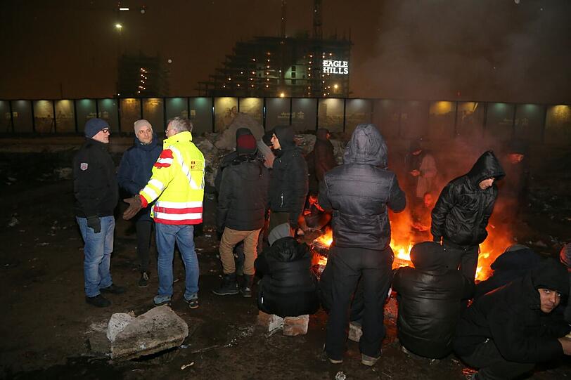 An improvisierten Feuern und in der &bdquo;total verfallenen&ldquo; Halle suchen die Flüchtlinge etwas Schutz vor der Kälte.