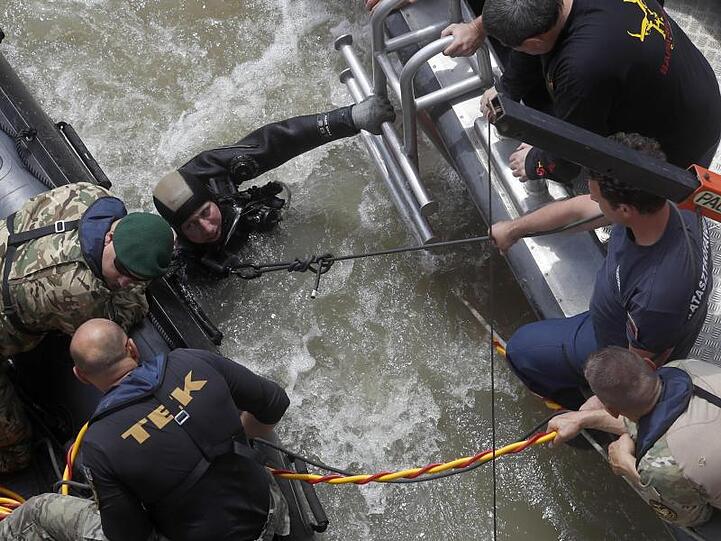 Ein Taucher spricht mit Rettungskräften. Rund 100 Kilometer südlich von Budapest konnte ein weiteres Opfer der Schiffskatastrophe geborgen werden.