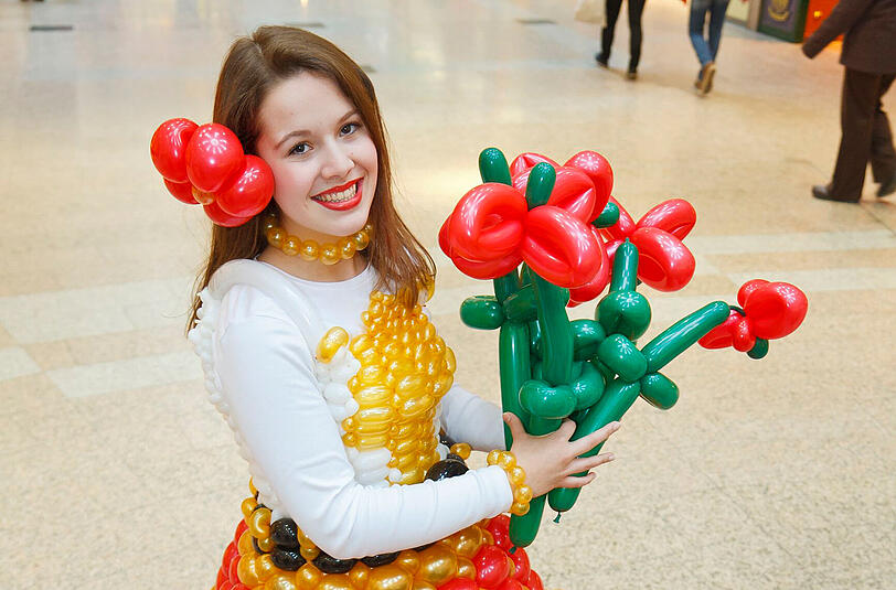 Am Ende der Ausstellung verteilt eine Dame Ballonblumen.