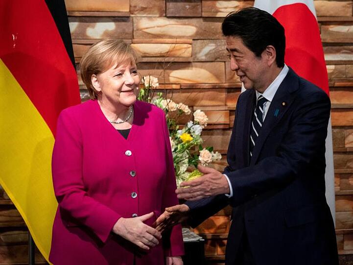 Angela Merkel wird von Shinzo Abe begrüßt.