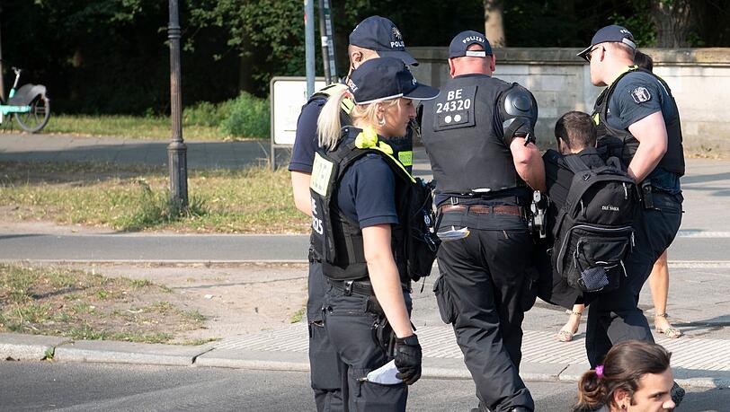 Die Polizei trägt einen Aktivisten der Gruppe Letzte Generation weg, der mit anderen die Fahrbahnen rund um die Siegessäule in Berlin blockiert hat.