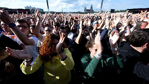 Fans verfolgen beim Fan Fest EURO 2024 auf der Theresienwiese das Konzert von Mark Forster auf der Bühne.