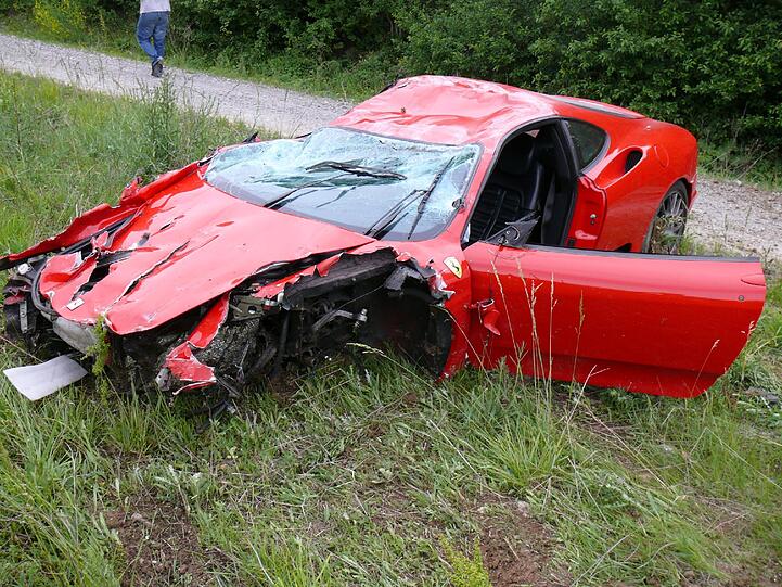 Das Foto der Polizei zeigt einen roten Ferrari mit Totalschaden, der am Donnerstagabend nach einem Verkehrsunfall neben der Autobahn A3 bei Mainstockheim (Landkreis Kitzingen / Unterfranken) stehen. Den Schaden schätzt die Autobahnpolizei auf über 60.000 Euro. Der französische Fahrer des Wagens, überstand den Unfall fast unverletzt.