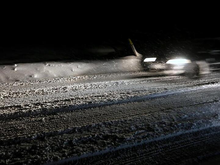 Ein Auto fährt auf schneeglatter Straße. Foto: Karl-Josef Hildenbrand/Archiv