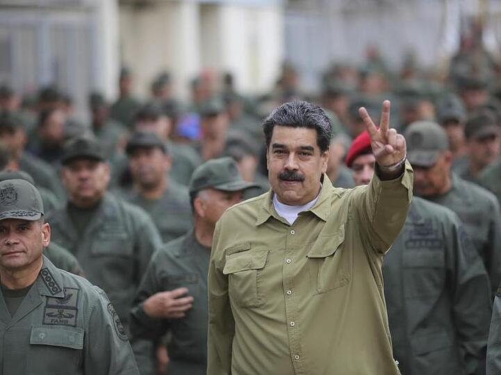 Umgeben von Soldaten zeigt Präsident Nicolás Maduro bei einem Truppenbesuch das Siegeszeichen.