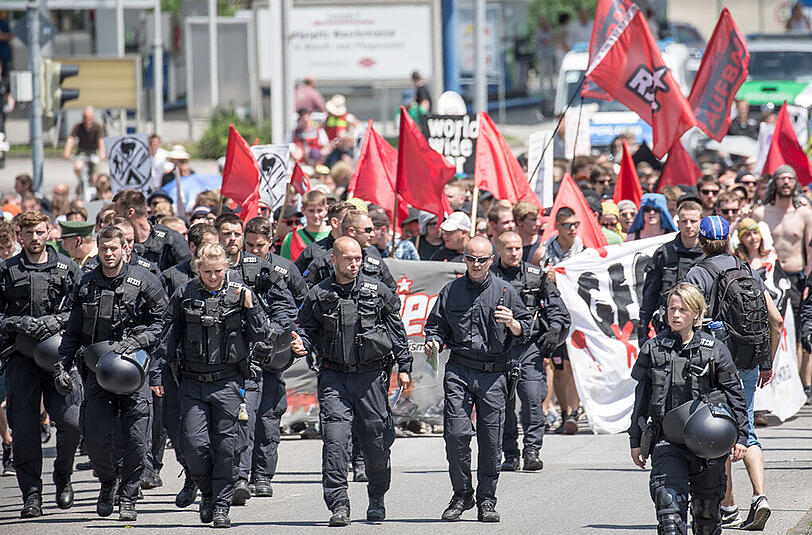 Poilizisten gehen vor den Demonstranten