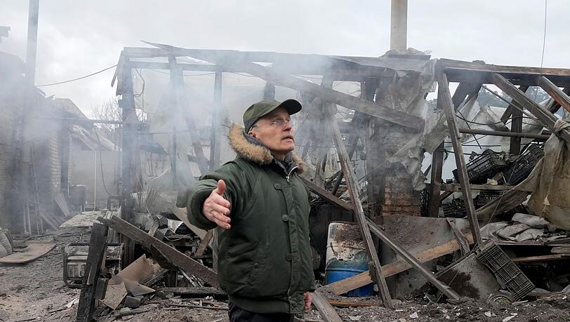 Ein Mann steht neben einem durch russischen Artilleriebeschuss zerstörten Haus in der Nähe Kiews. Ein Mann steht neben einem durch russischen Artilleriebeschuss zerstörten Haus in der Nähe Kiews.