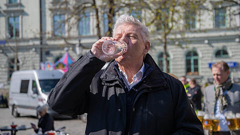 Dieter Reiter (SPD) trinkt Wasser aus einem Brunnen. Münchens Oberbürgermeister nennt die Wasser-Diskussion im Landtag "verstörend".