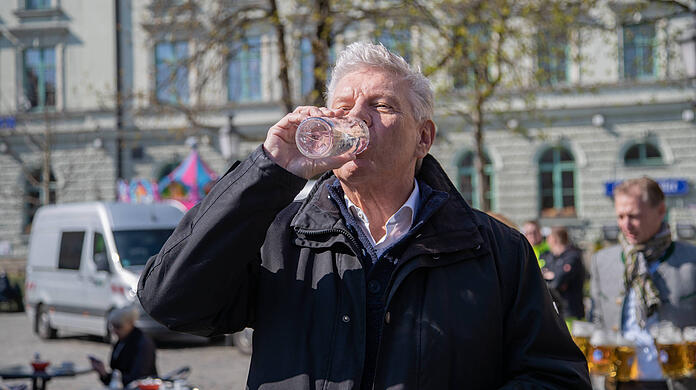 Dieter Reiter (SPD) trinkt Wasser aus einem Brunnen. Münchens Oberbürgermeister nennt die Wasser-Diskussion im Landtag "verstörend".