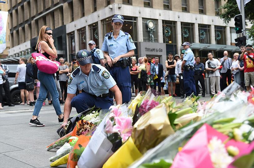 Tausende Menschen legen in der Nähe des "Lindt"-Cafés Blumen nieder.