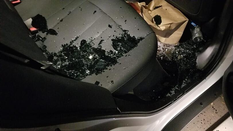 Das zerbrochene Glas liegt auf dem Rücksitz seines Autos. Das zerbrochene Glas liegt auf dem Rücksitz seines Autos.