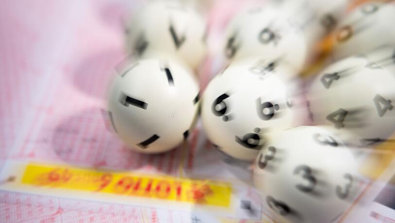 Lotto-Kugeln liegen auf einem Lottoschein.