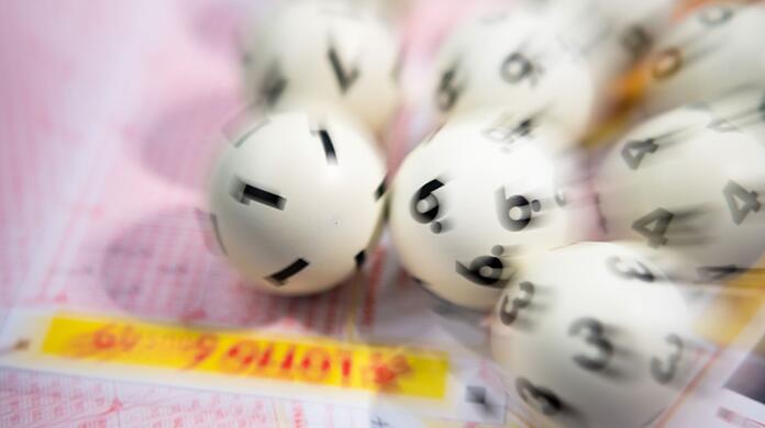Lotto-Kugeln liegen auf einem Lottoschein.