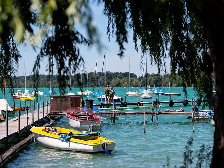 Boote liegen am Wörthsee an einem Steg. Foto: Sven Hoppe/dpa