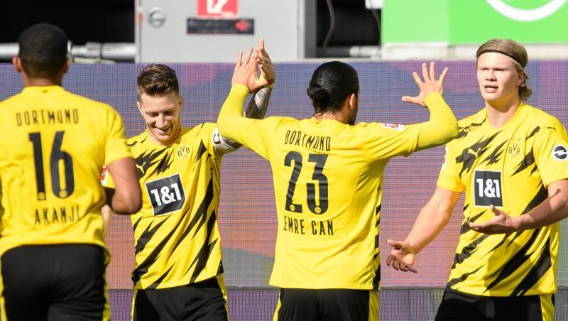 Dortmunds Matchwinner Erling Haaland (r) wird von seinen BVB-Teamkollegen in Wolfsburg gefeiert.
