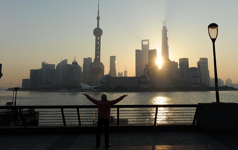 Eine Bewohnerin von Shanghai macht in Sichtweite der Wolkenkratzer von Shanghai-Pudong Frühsport.