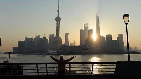 Eine Bewohnerin von Shanghai macht in Sichtweite der Wolkenkratzer von Shanghai-Pudong Frühsport.
