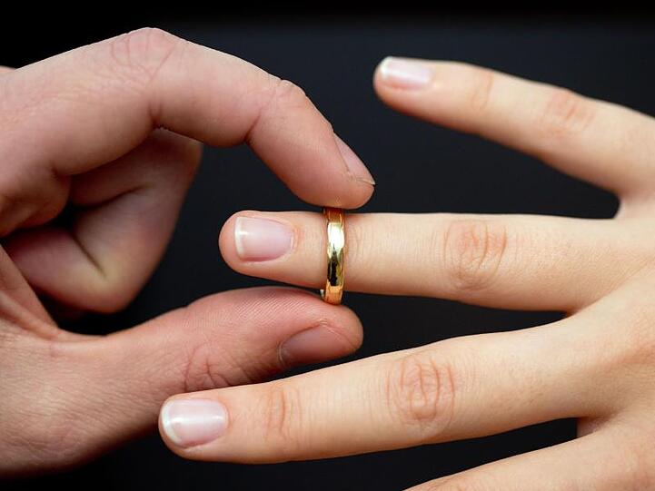 Ein Ehering wird an den Finger einer Braut gesteckt. Foto: Friso Gentsch/Archiv