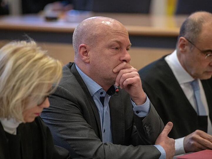 Joachim Wolbergs, suspendierter Regensburger Oberbürgermeister, sitzt zwischen seinen Verteidigern. Foto: Armin Weigel/Archivbild