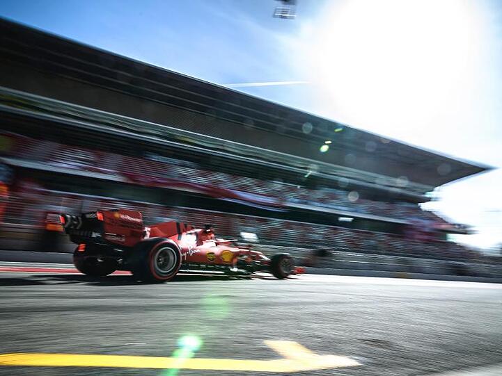 Sebastian Vettel fährt im roten Ferrari an der Tribüne des Circuit de Barcelona-Catalunya vorbei.