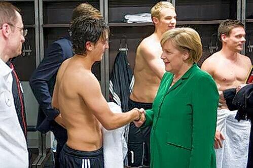 Gestatten, Merkel: Die Bundeskanzlerin stattete nach dem 3:0 in der EM-Qualifikation der Nationalelf einen Besuch in der Kabine ab, hier beglückwünschte sie Mesut Özil zu seiner famosen Leistung.