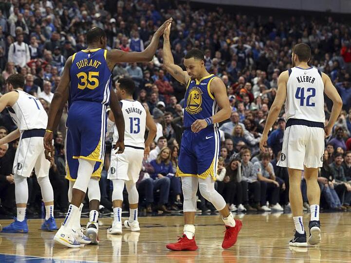 Kevin Durant (2.v.l) und Stephen Curry feiern den Sieg gegen die Dallas Mavericks.