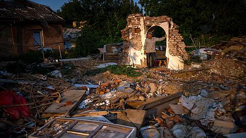Ein Mann steht vor den Trümmern seines Hauses, das von der russischen Armee bombardiert wurde.