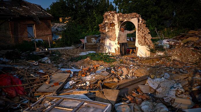 Ein Mann steht vor den Trümmern seines Hauses, das von der russischen Armee bombardiert wurde.