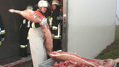 Da bekommt der Feuerwehrler unfreiwillig Metzger-Erfahrung: Ein Lkw kippte um und die Feuerwehr musste umladen. In diesem Fall eben bei Schweinehäften Da bekommt der Feuerwehrler unfreiwillig Metzger-Erfahrung: Ein Lkw kippte um und die Feuerwehr musste umladen. In diesem Fall eben bei Schweinehäften