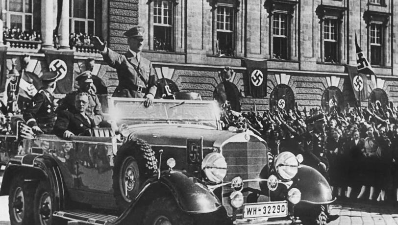 In einem Auto stehend grüßt Adolf Hitler am 14.03.1938 in Wien, Österreich, die ihm zujubelnde Menschenmenge. In einem Auto stehend grüßt Adolf Hitler am 14.03.1938 in Wien, Österreich, die ihm zujubelnde Menschenmenge.