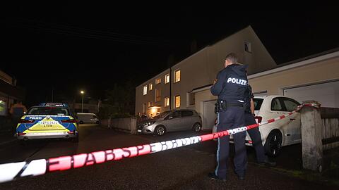 Polizisten am Tatort vor dem Haus in Langweid, in dem drei Menschen erschossen wurden.