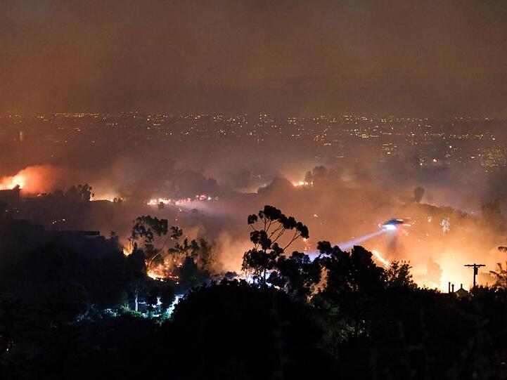 Ein Hubschrauber fliegt über einem Wohngebiet, das vom sogenannten "Getty"-Feuer betroffen ist.