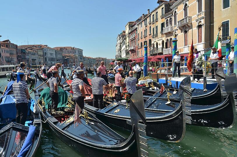 Gondolierie bei einer Gedenkzeremonie für Joachim Vogel in Venedig. Ihre Boote tragen schwarze Trauerbänder.